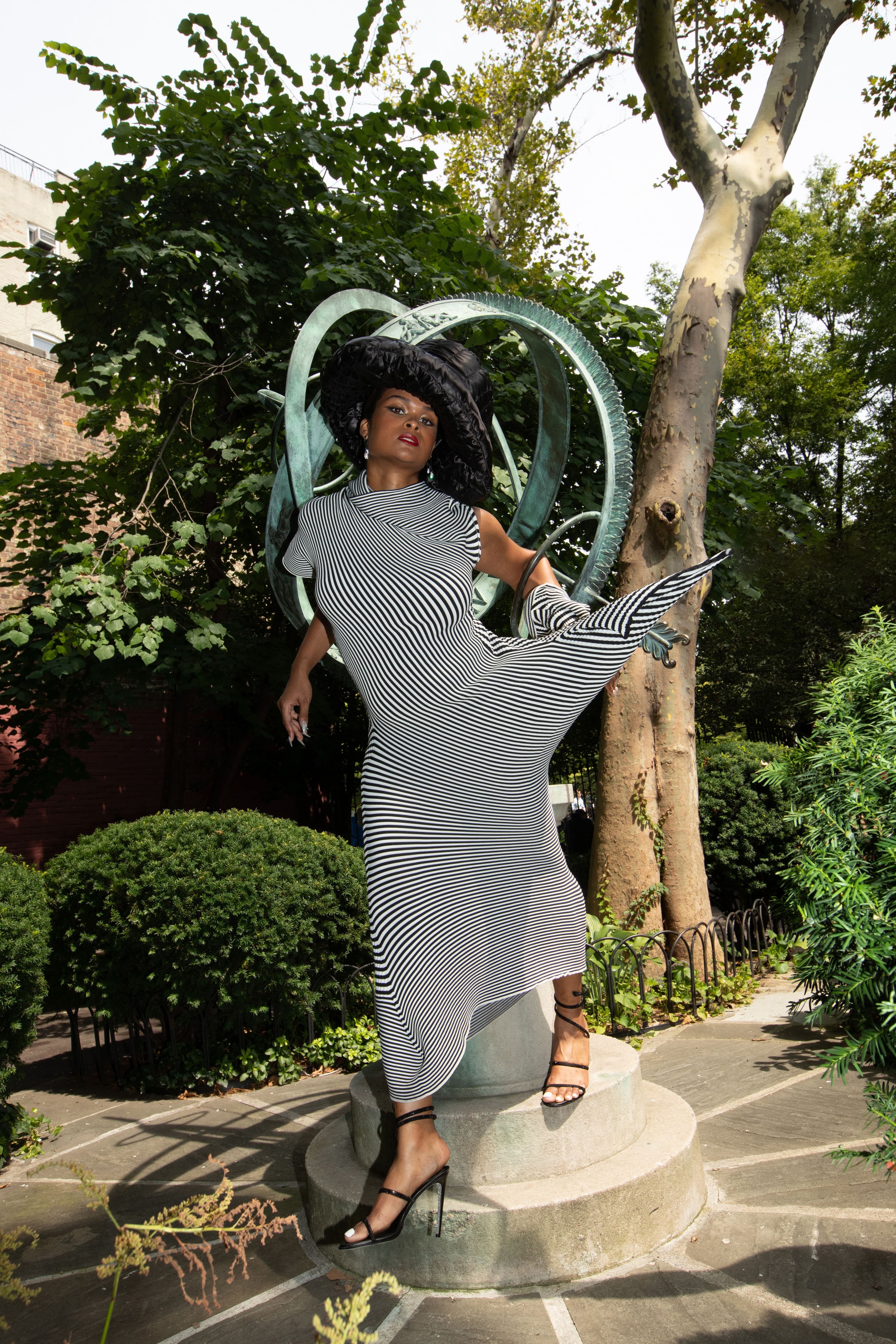 All clothing by Issey Miyake. Hat by Xtinel. Shoes by René Caovilla. Earrings by Alexis Bittar.