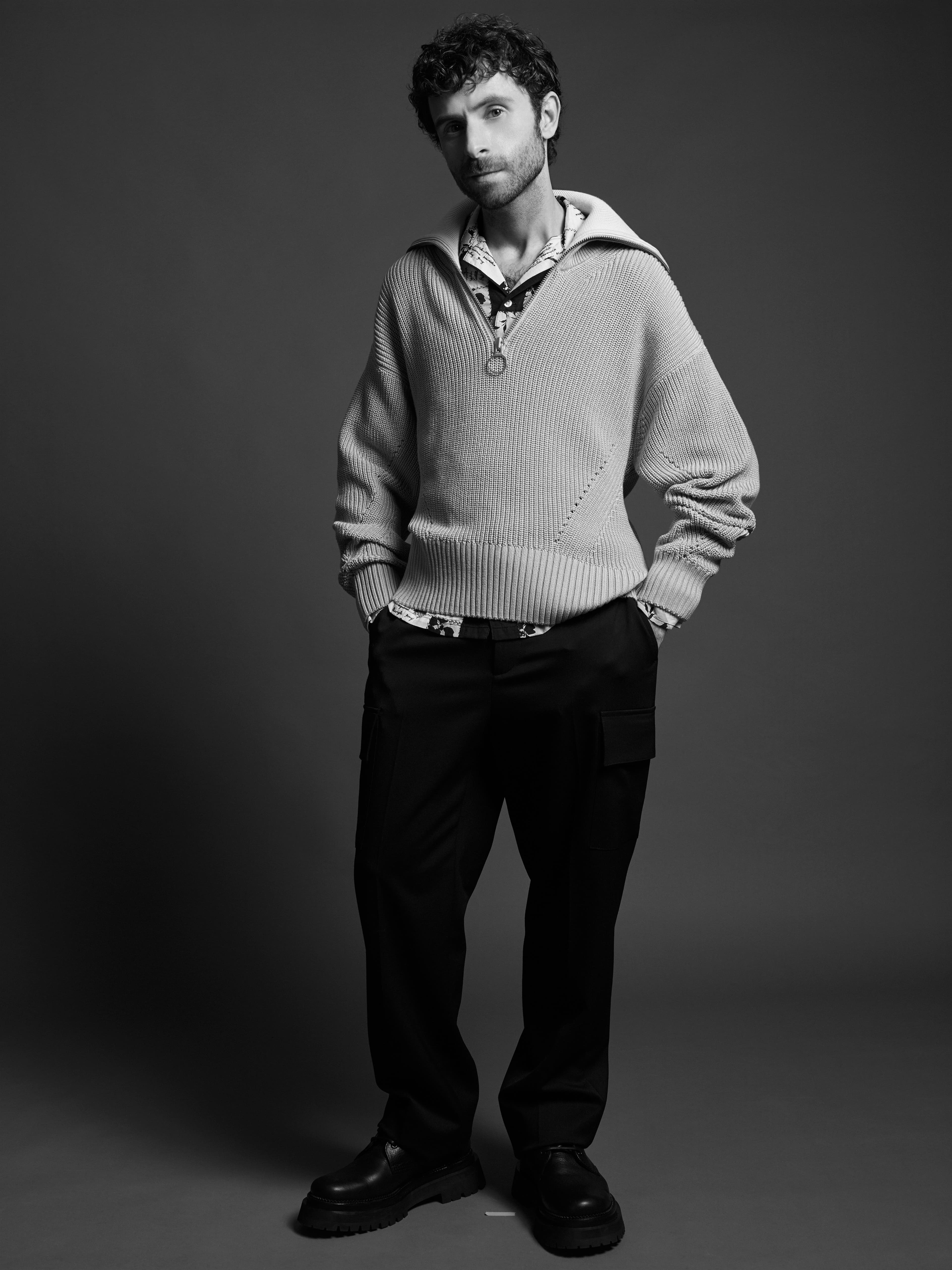 Sweater and shoes by AMI Paris. Shirt by Bode. Pants by Valentino.