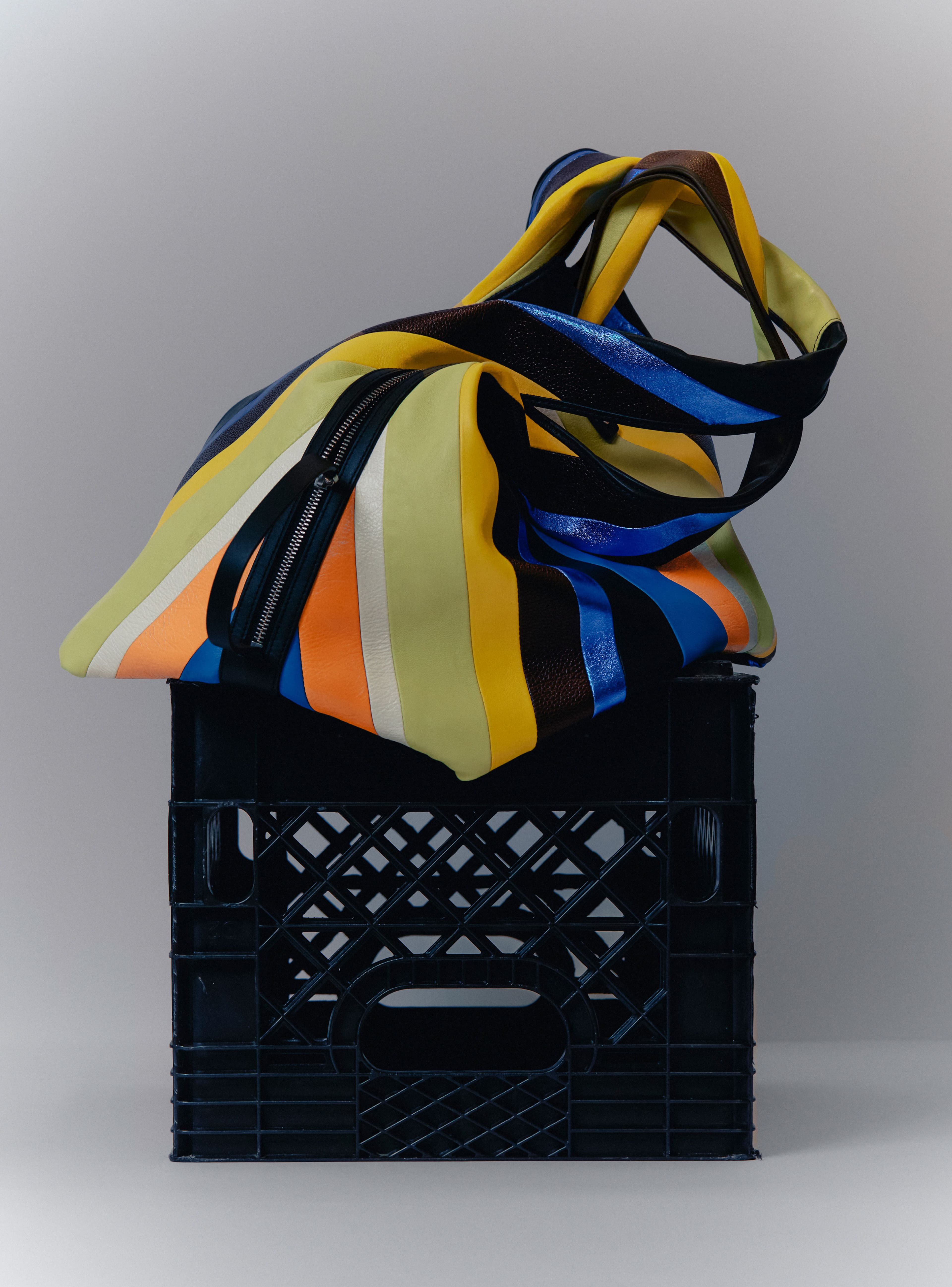 Launched in the city and based in SoHo, the 3.1 Phillip Lim brand was cofounded by designer Phillip Lim and entrepreneur Wen Zhou with an emphasis on sustainability and community involvement. Adhering to these principles, the geometric Large Prism tote pulls together leftover archival leather to create a striped array of colors which can be hoisted by hand or with its arcing shoulder strap, also composed from multi-colored leather.