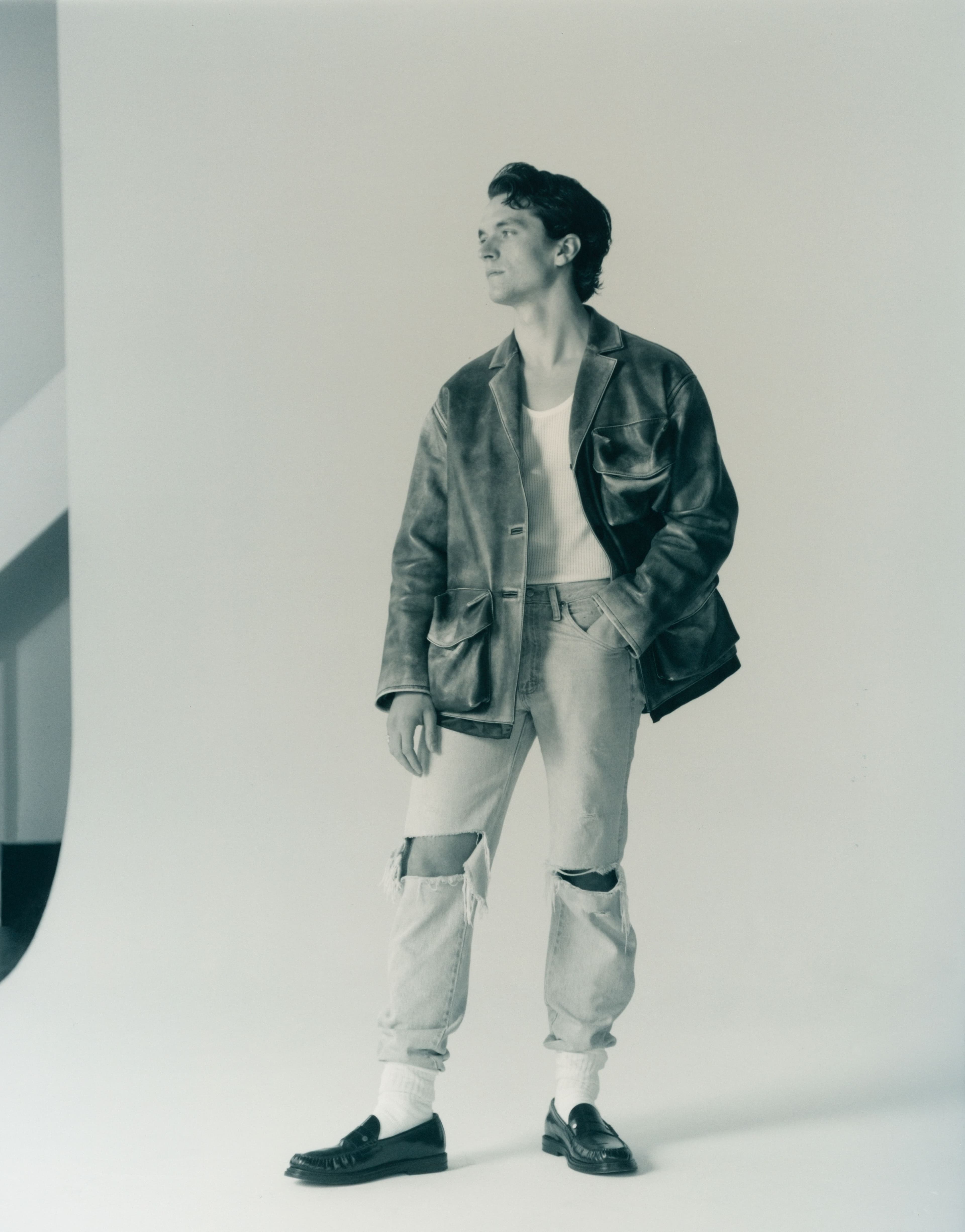 Jacket by Miu Miu. Top and jeans, stylist’s own. Shoes by Dunhill. Socks by Falke.