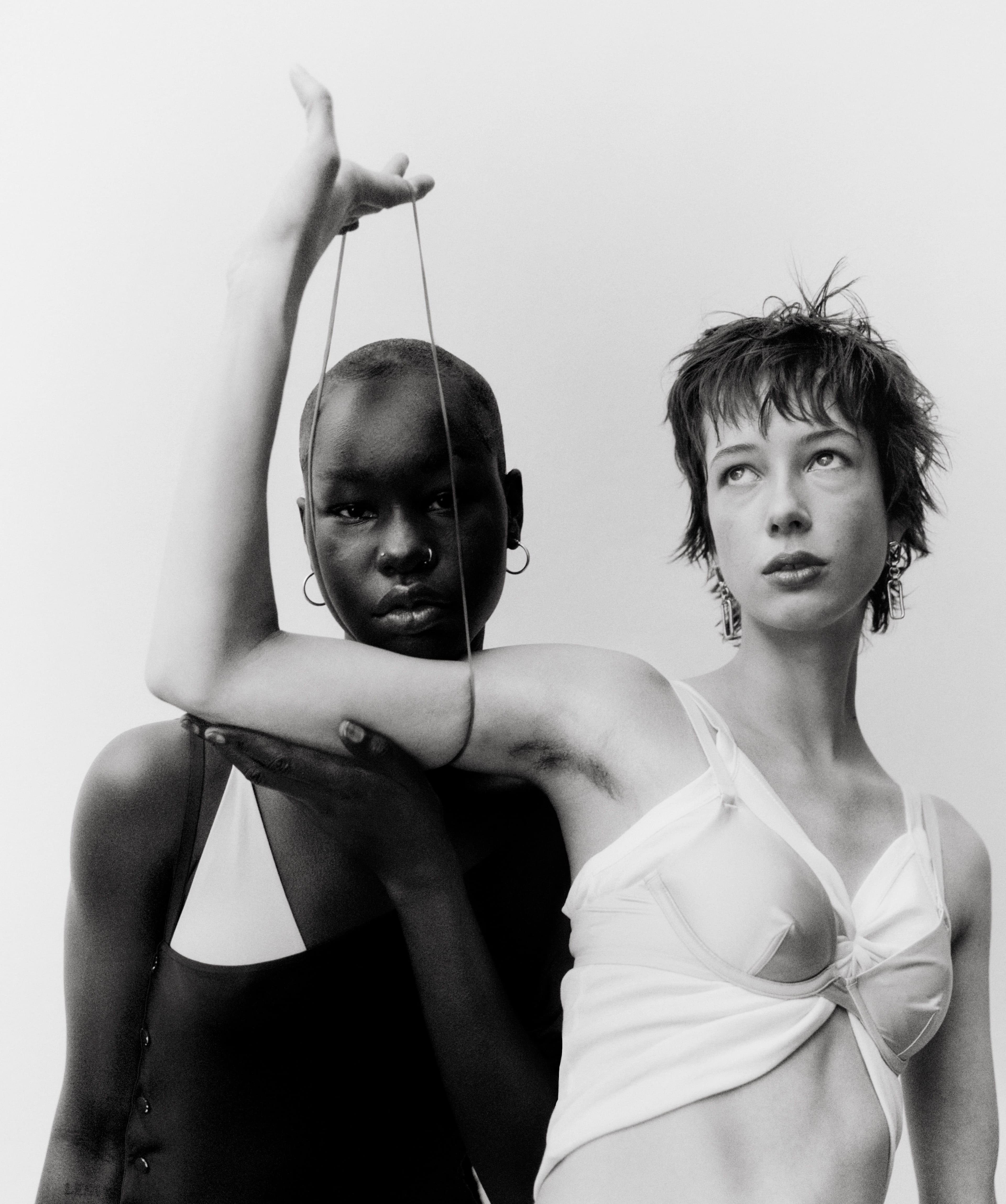 From left: Noi Dwol wears vintage dress by Paco Rabanne from the Albright Fashion Library. Bra by Baserange. Earrings by Santangelo. Bracelet by Laura Lombardi. Johnson wears top by Araks. Bra by Cuup. Earrings by Laura Lombardi.