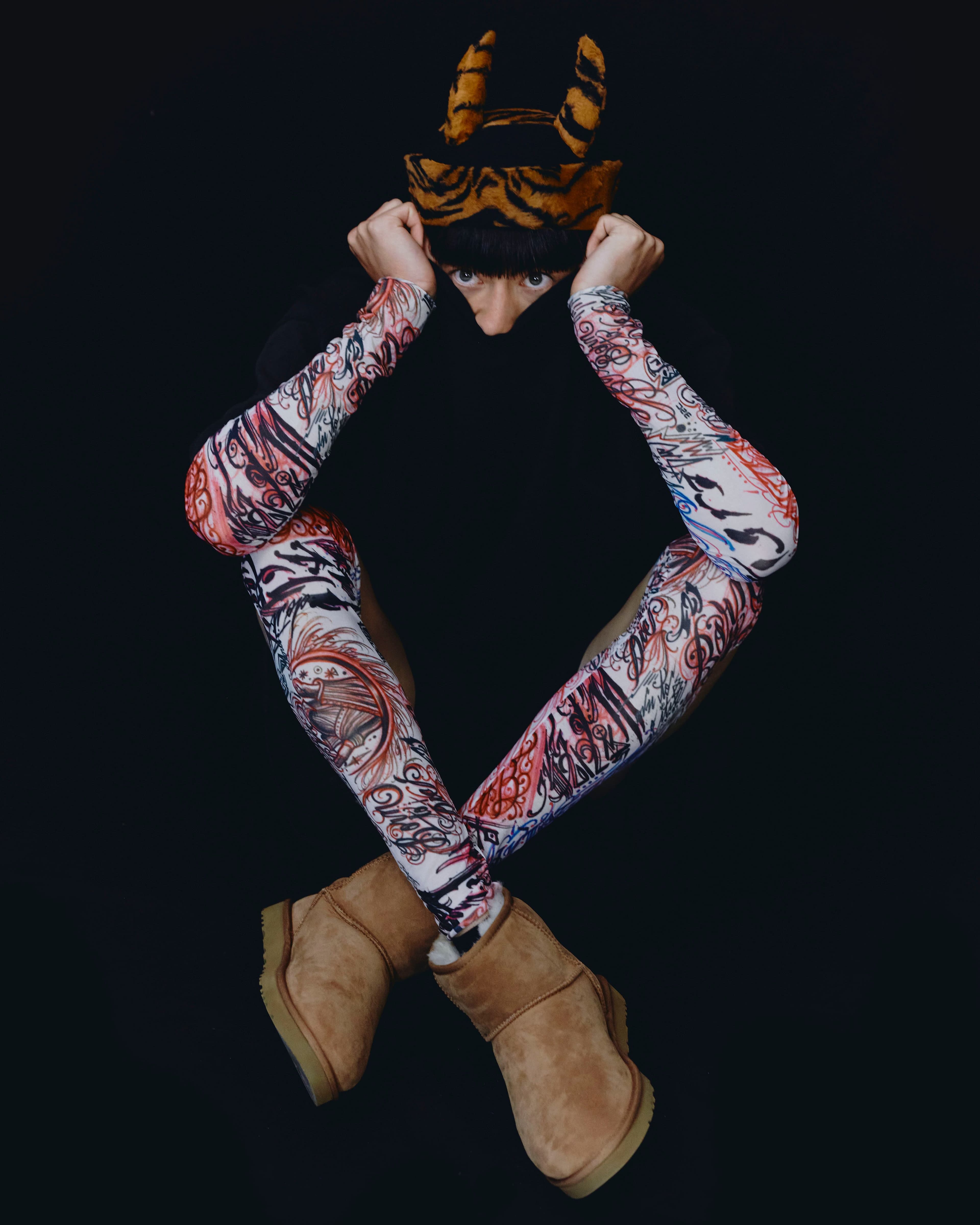 Top and shorts by Willy Chavarria. Vintage sleeves and tights by Comme des Garçons Homme Plus from the 20Age Archive. Vintage hat by Jean Paul Gaultier from the 20Age Archive. Shoes by UGG.