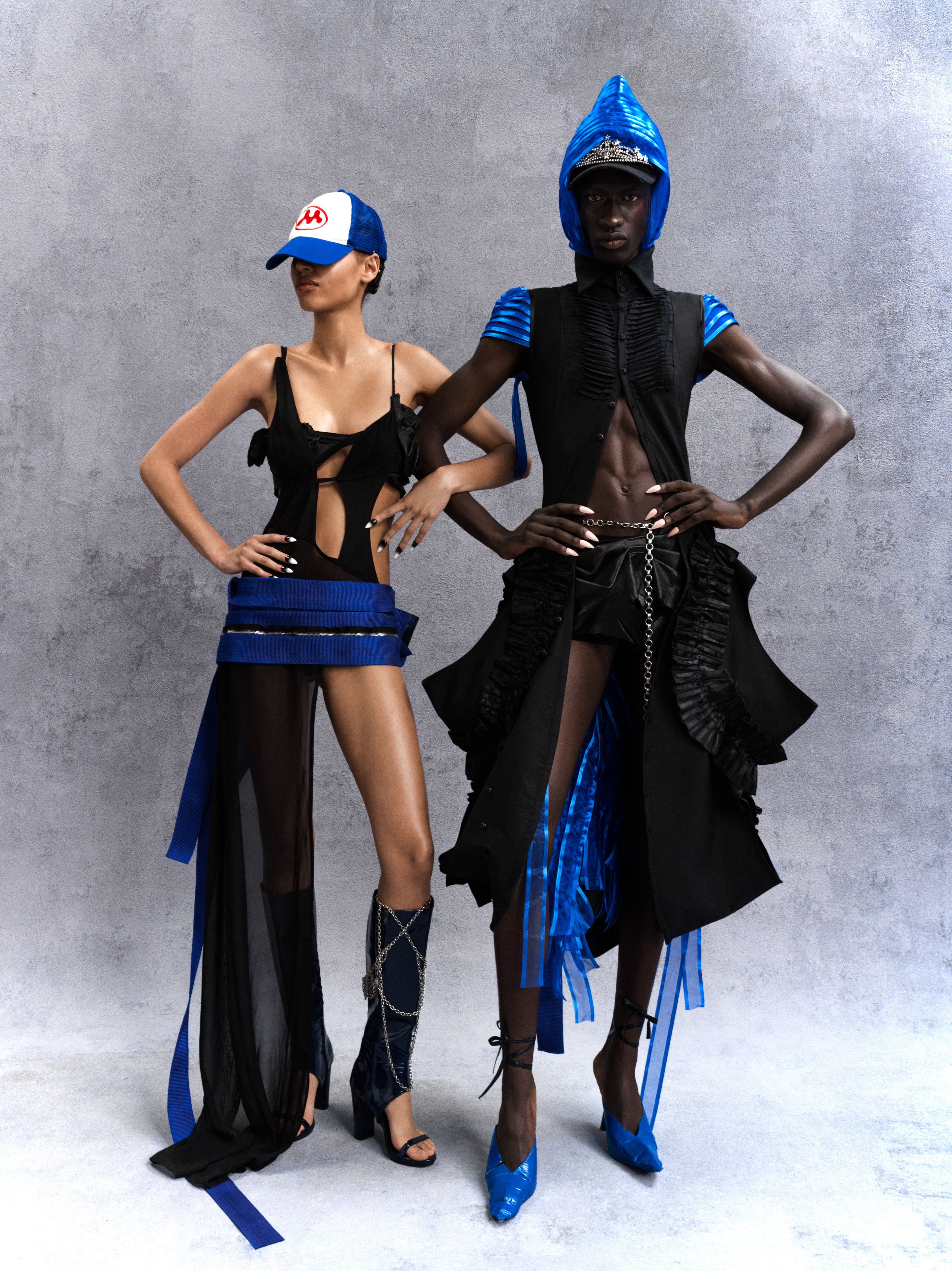 From left, Erika wears dress by Ecke Faei. Skirt by Maximilian Raynor. Bra by Rika Kim. Hat by Mowalola. Shoes by Dipetsa. All jewelry, stylist’s own. Mohamadou wears dress by Sim Soo Hyun. Dress, worn underneath, and shoes by Maximilian Raynor. Skirt by Rika Kim. Cap by Dsquared2. All jewelry, stylist’s own.