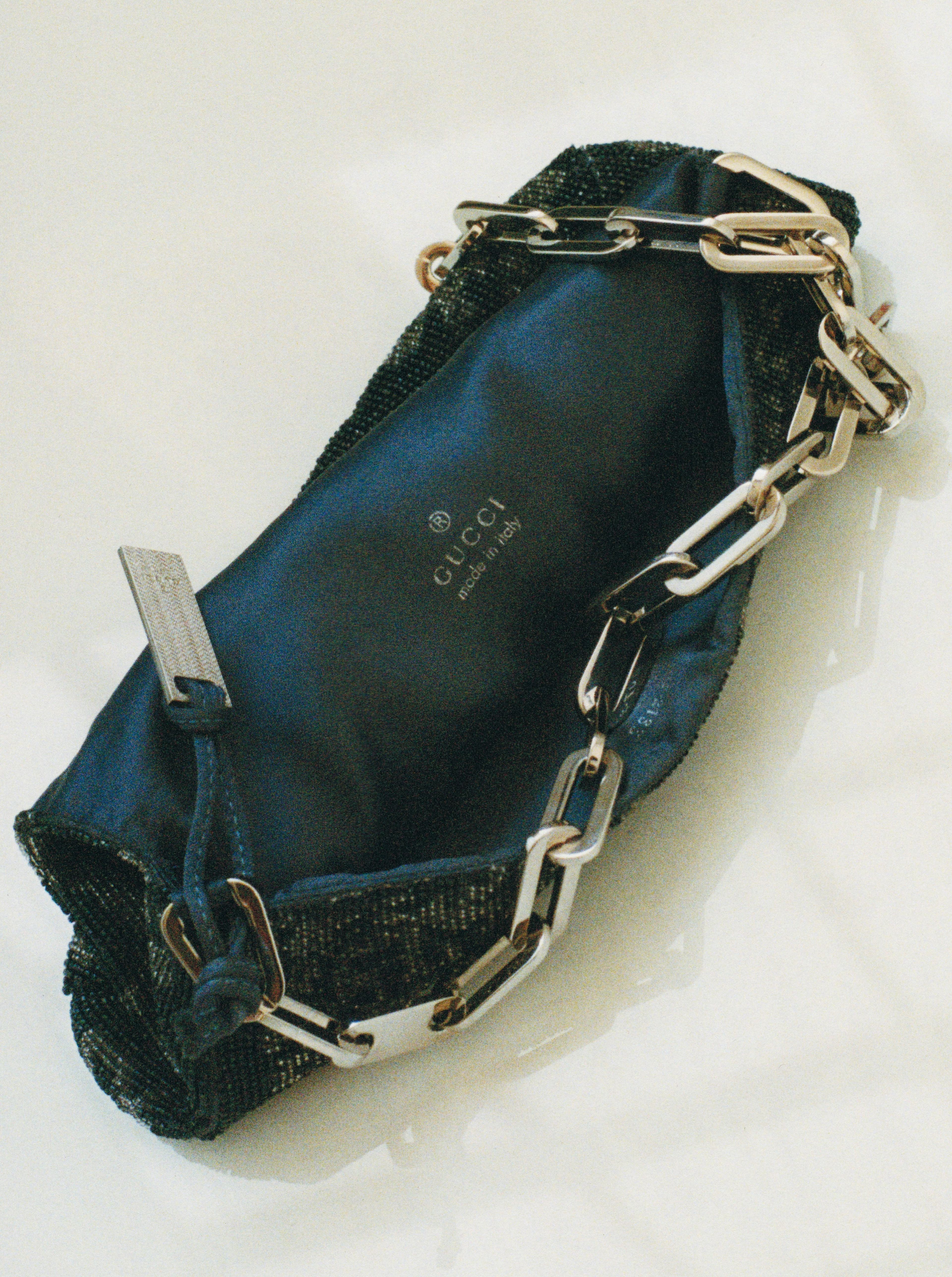 Vintage bag by Gucci, Spring 2000.. Tom Ford was responsible for infusing the mid-nineties and the early aughts with opulent and minimalist sex appeal in his iconic campaigns and collections that defined an era that continues to echo through the zeitgeist. This 23-year-old beaded evening bag, lined with the jewel tone of washed blue silk satin and the bold silver chain, is the epitome of hedonistic glamor. Tim Blanks once noted that Ford’s designs of the time “lit the fuse of the sex bomb.“